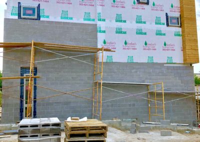 sustainable design build denver colorado west colfax 1265 xavier during construction cmu brick install blue stain pine