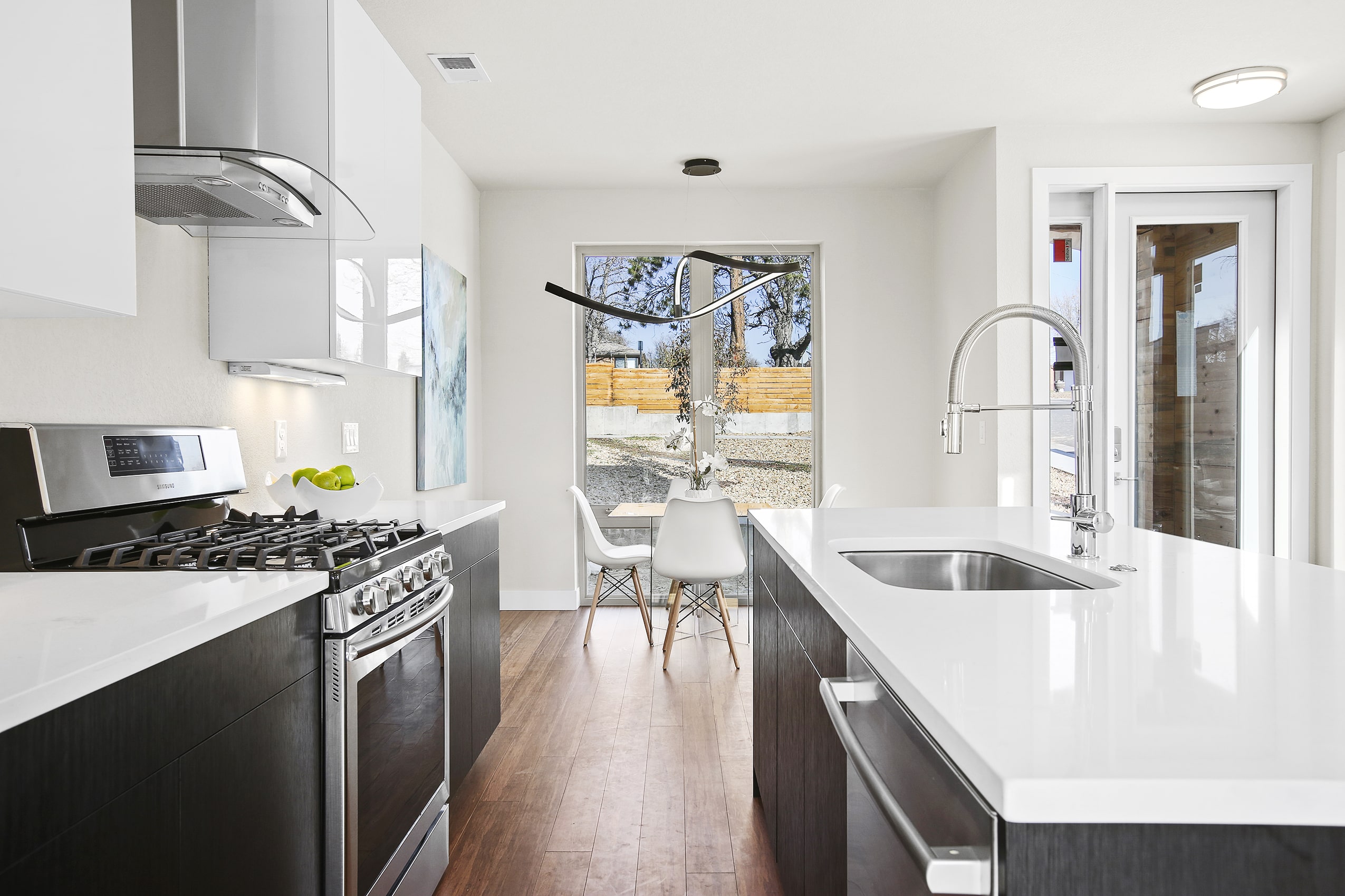 quartz counter modern finishes sink white pendant lamp kitchen range hood kitchen