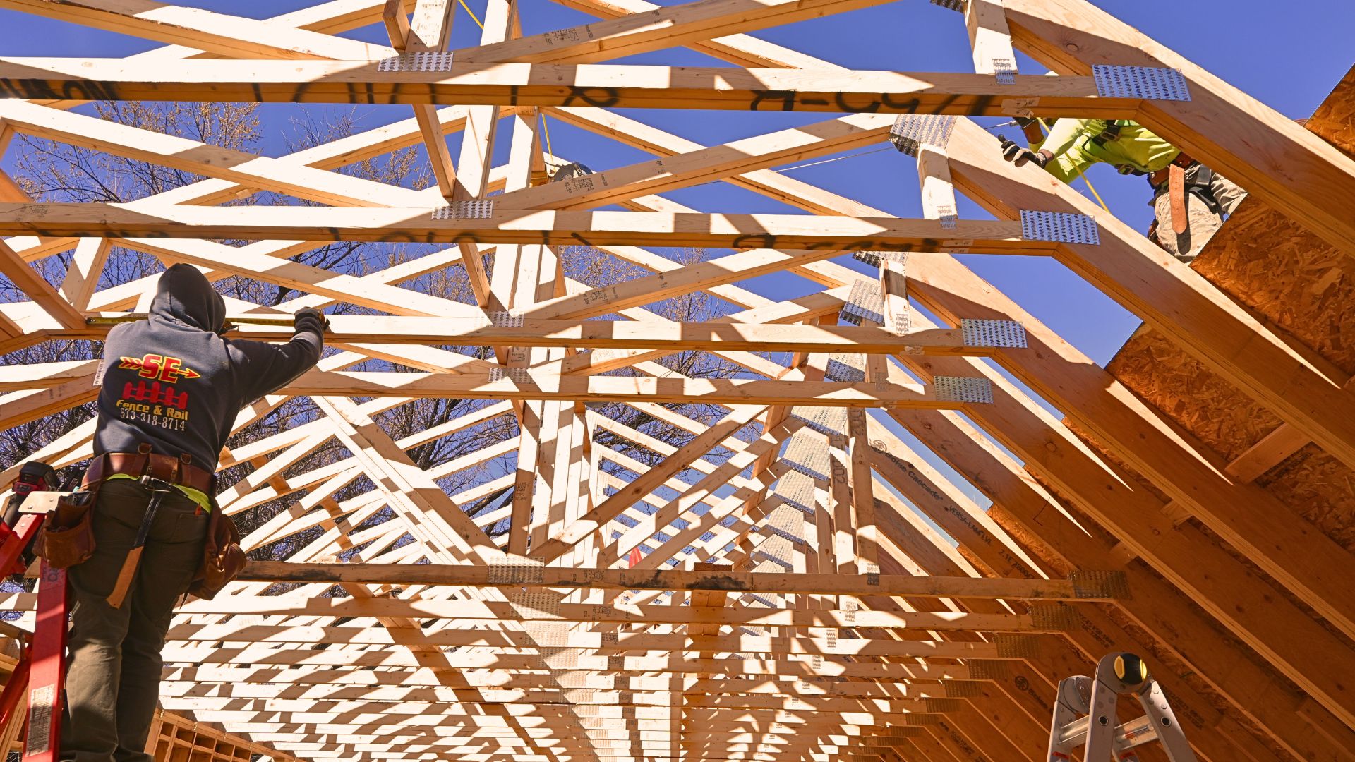 Why October Is the Perfect Time to Start Thinking About a Home Renovation Overhead framing with two workers with Sustainable Design Build erecting roof trusses in a Denver Bungalow Home in October